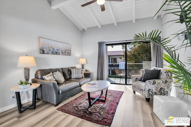 living room with ceiling fan, beamed ceiling, and light wood-type flooring