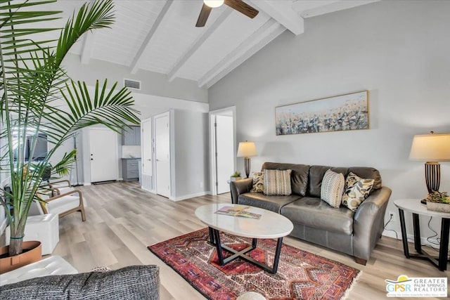 living room with beam ceiling, ceiling fan, light hardwood / wood-style flooring, and high vaulted ceiling