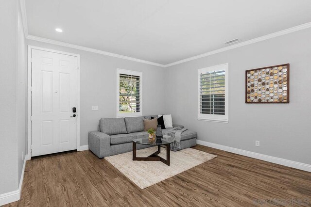 living room with plenty of natural light, hardwood / wood-style floors, and crown molding