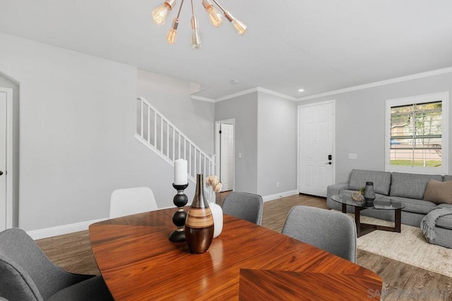 dining space with dark hardwood / wood-style flooring, ornamental molding, and an inviting chandelier