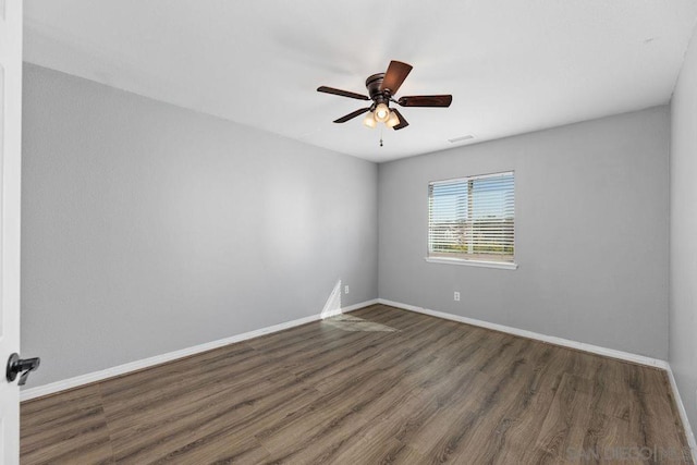 empty room featuring ceiling fan and dark wood-type flooring