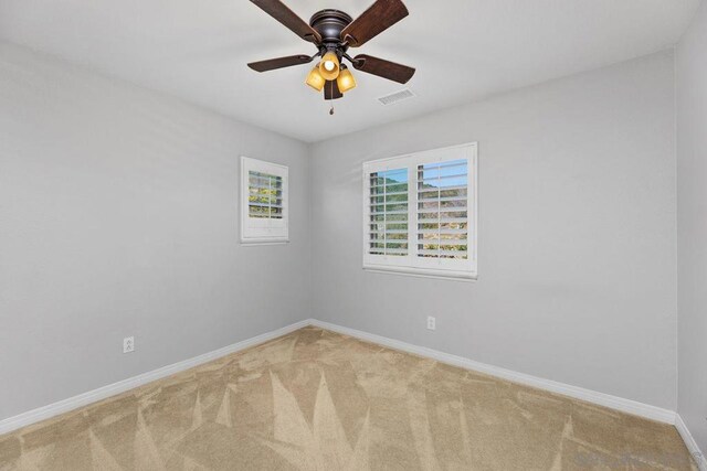 empty room featuring carpet floors and ceiling fan