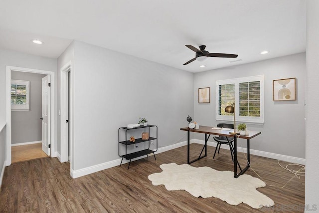 home office with ceiling fan and dark hardwood / wood-style flooring