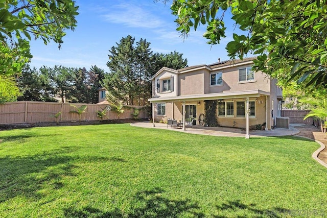 back of house with central AC unit, a lawn, and a patio