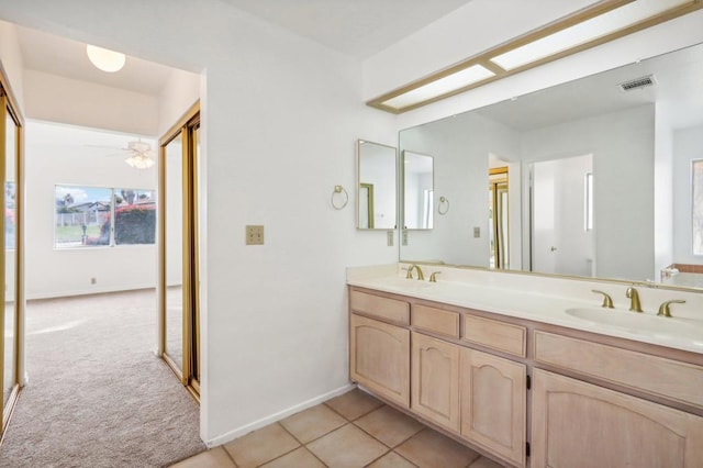 bathroom featuring vanity, tile patterned floors, ceiling fan, and a skylight