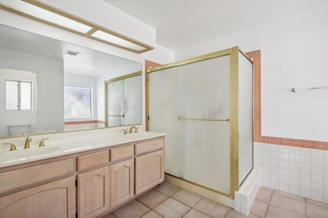 bathroom featuring tile patterned flooring, vanity, toilet, and an enclosed shower