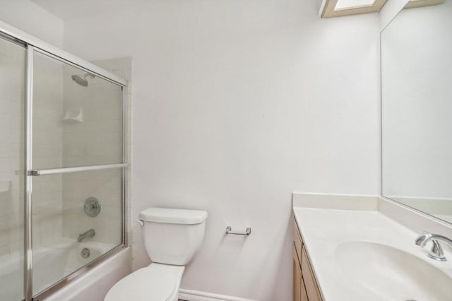 full bathroom featuring shower / bath combination with glass door, vanity, and toilet