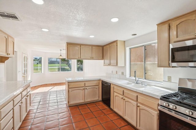 kitchen featuring light brown cabinetry, sink, kitchen peninsula, and appliances with stainless steel finishes