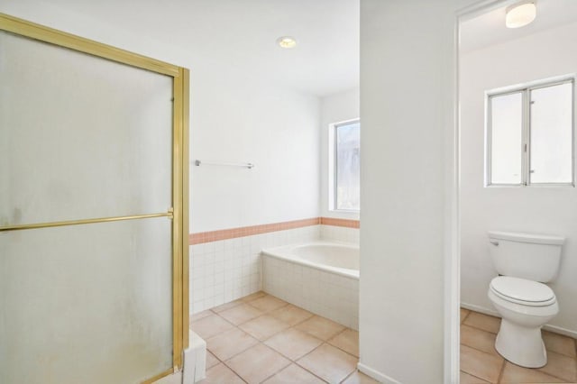 bathroom featuring tile patterned floors, toilet, and separate shower and tub