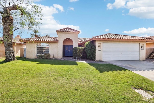 mediterranean / spanish home with a garage and a front yard