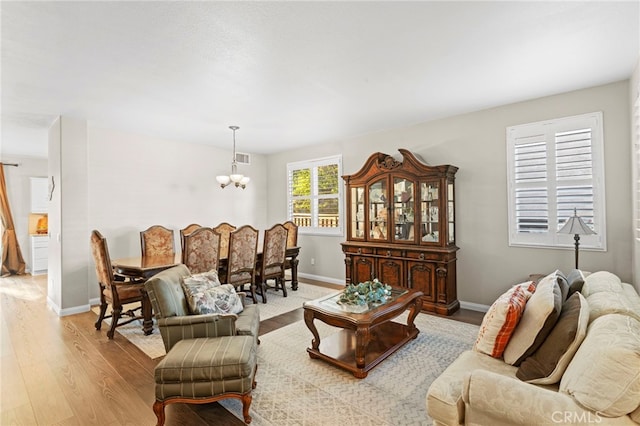 living room featuring a notable chandelier and light hardwood / wood-style flooring