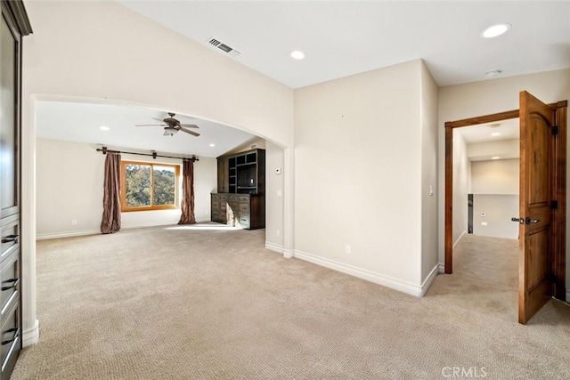 unfurnished living room featuring ceiling fan and light colored carpet