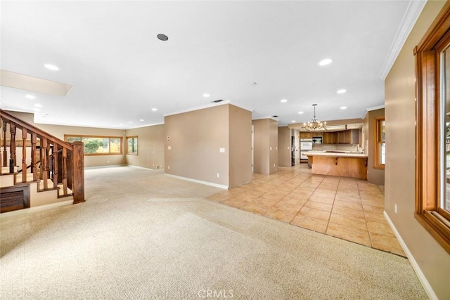 unfurnished living room featuring light colored carpet, an inviting chandelier, and ornamental molding