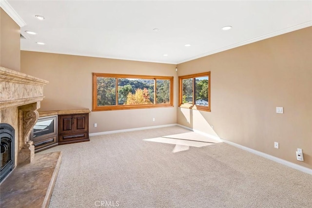 unfurnished living room featuring light carpet, a premium fireplace, and ornamental molding