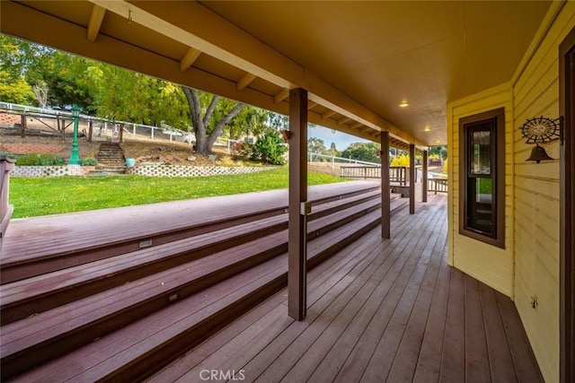 wooden terrace featuring a lawn