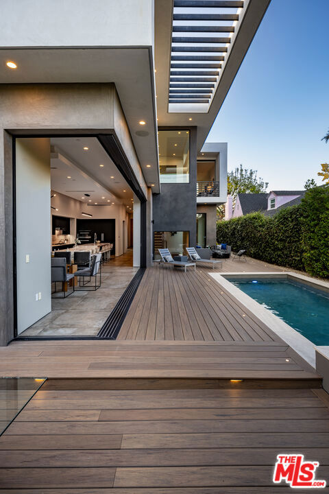 deck at dusk featuring a fenced in pool