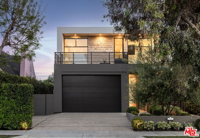 contemporary house with a garage and a balcony