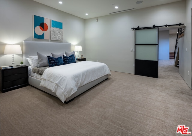 carpeted bedroom featuring a barn door