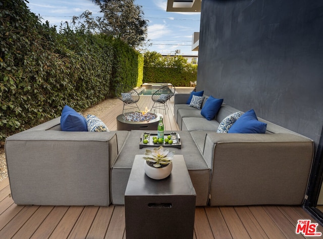 wooden terrace featuring outdoor lounge area and a hot tub