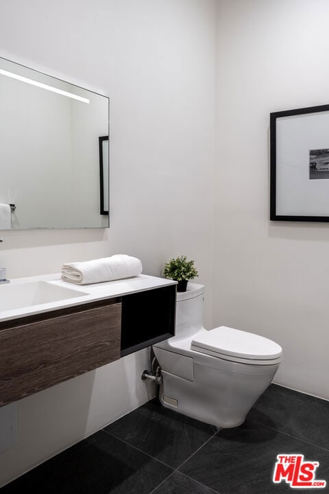 bathroom featuring tile patterned flooring, vanity, and toilet