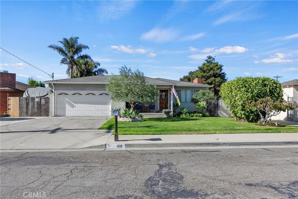 single story home featuring a front yard and a garage