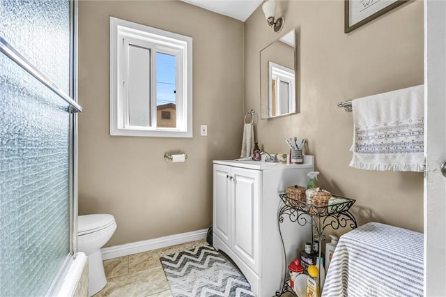 bathroom with tile patterned floors, toilet, vanity, and walk in shower