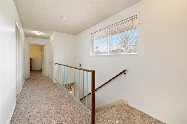 hall with carpet and a textured ceiling