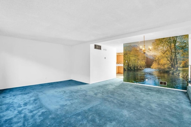 carpeted empty room with a notable chandelier