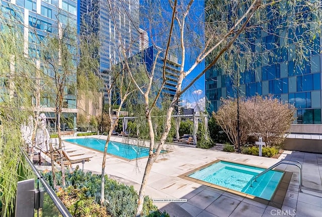 view of swimming pool featuring a patio area and a hot tub