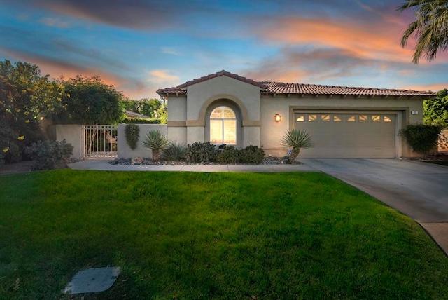 mediterranean / spanish-style home with a lawn and a garage