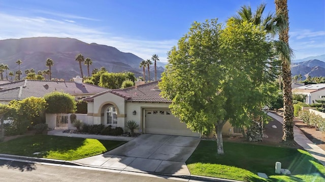 view of front of home featuring a mountain view, a garage, and a front yard