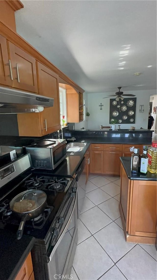 kitchen featuring ceiling fan, sink, light tile patterned floors, and stainless steel appliances