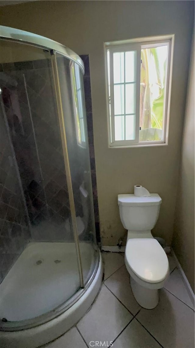 bathroom featuring tile patterned floors, walk in shower, and toilet