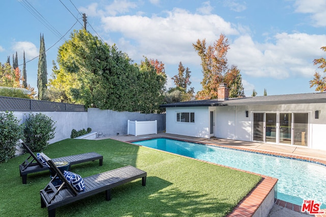 view of pool featuring a patio area and a yard