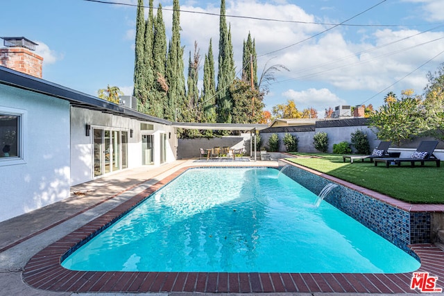 view of swimming pool with pool water feature and a yard