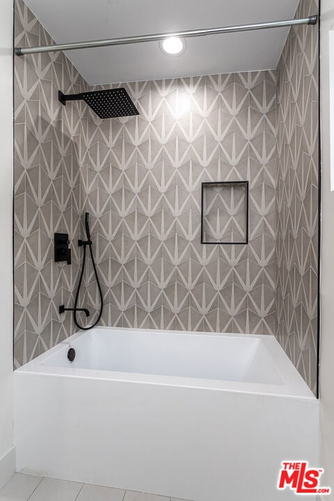 bathroom featuring tile patterned floors and tiled shower / bath