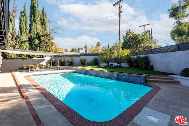 view of swimming pool with a patio area, pool water feature, and a yard