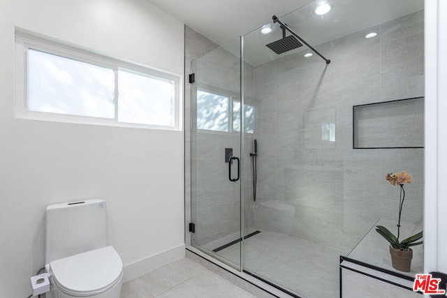 bathroom with tile patterned flooring, toilet, and an enclosed shower