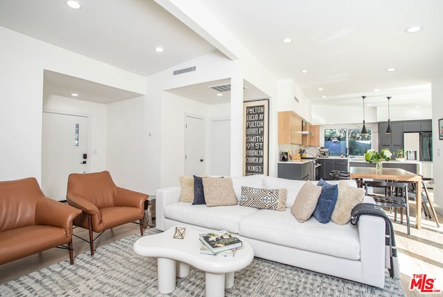 living room featuring light wood-type flooring and lofted ceiling