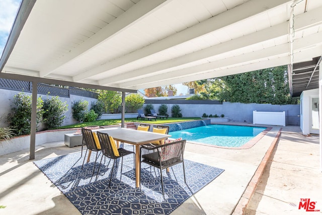 view of swimming pool with a patio area, pool water feature, and a yard