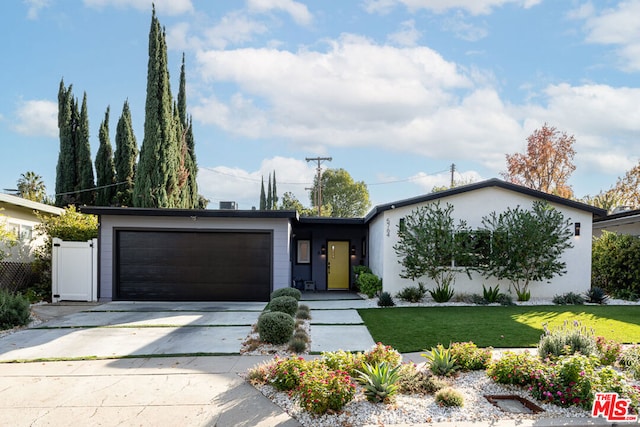 view of front of home featuring a garage and a front lawn