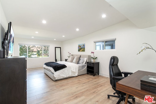 bedroom with light wood-type flooring and lofted ceiling