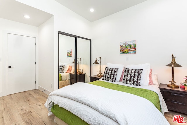 bedroom with light hardwood / wood-style flooring and a closet