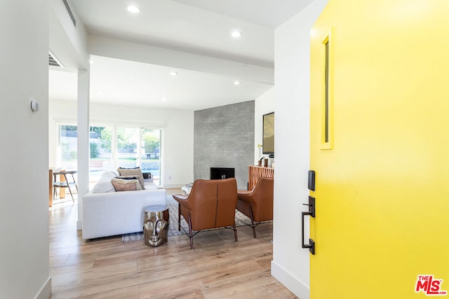 living room with a fireplace and light wood-type flooring