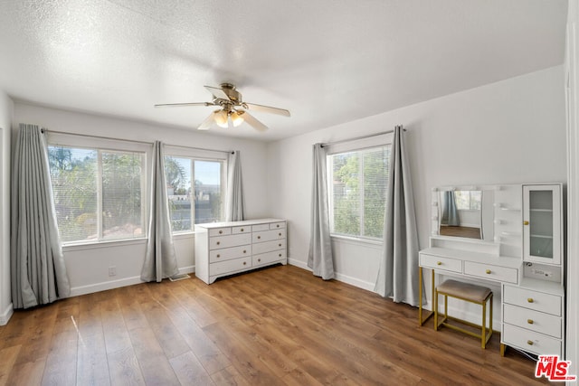 unfurnished bedroom featuring ceiling fan, a textured ceiling, and hardwood / wood-style flooring