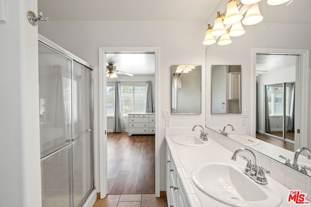 bathroom with hardwood / wood-style floors, ceiling fan, a shower with shower door, and vanity