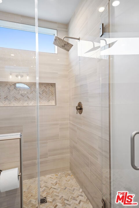 bathroom featuring a shower with door