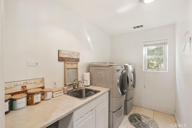 washroom with cabinets, sink, independent washer and dryer, and light tile patterned flooring