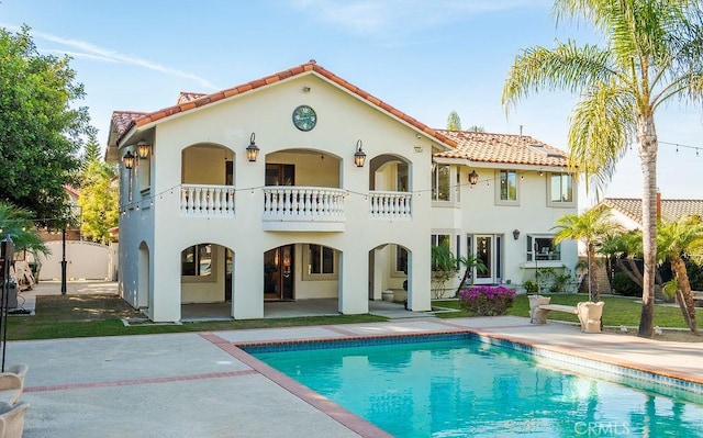 back of property with a balcony and a patio