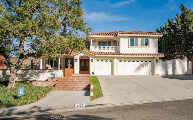 mediterranean / spanish-style house featuring a garage and a balcony